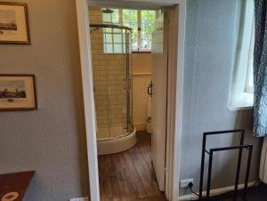 a bathroom with a walk in shower next to a window at Bossington Bunkhouse in Minehead