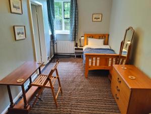 a bedroom with a bed and a table and a chair at Bossington Bunkhouse in Minehead