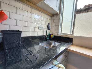 a kitchen counter with a sink and a window at Lofts Sky Life in São José dos Campos