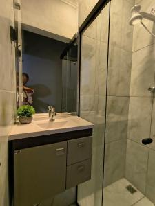 a bathroom with a sink and a shower at Lofts Sky Life in São José dos Campos
