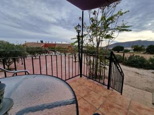 a balcony with a table and a wrought iron fence at Vagón con sesión de Jacuzzi in Caravaca de la Cruz