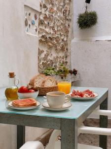 a table with a breakfast of bread and fruit on it at Casa junto al mar in Vinarós