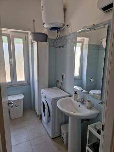 a bathroom with a washing machine and a sink at La Spiritiera in Minturno