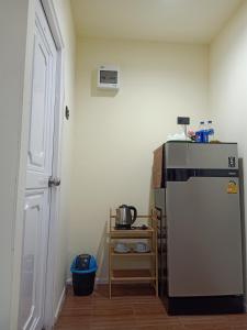 a small kitchen with a refrigerator and a table at Home No 3 khanom in Ban Thung O