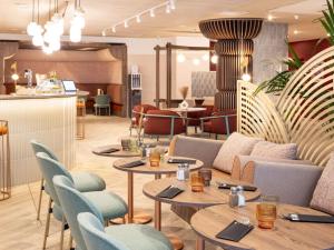 a restaurant with tables and chairs and a bar at Novotel Marseille Centre Prado Vélodrome in Marseille