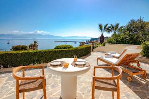 a table and chairs on a patio with a view of the water at Pelagia Apartments in Koroni