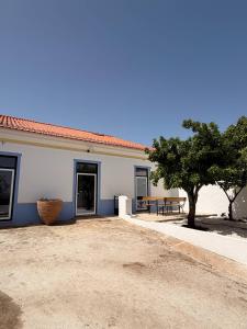 a white building with a tree in front of it at Fronteira in Fronteira