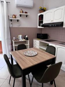a kitchen with a wooden table and chairs at Nonna Croce Home in San Giovanni Gemini