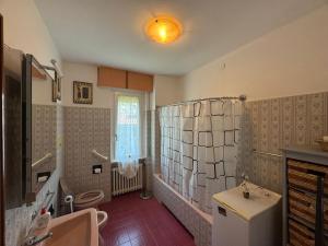 a bathroom with a sink and a toilet and a window at Casa Claudia in Riva di Solto +9 photos