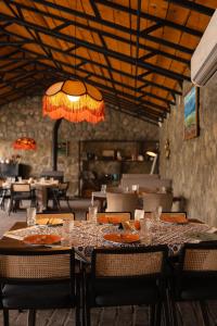 a dining room with a table and chairs and a chandelier at Vineyard Hotel & Winery in Napareuli