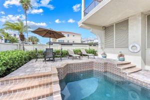 a swimming pool with a patio with a table and chairs at Admirals Watch - 673 in Siesta Key +7 photos
