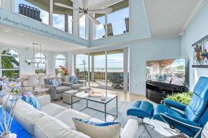 a living room with white furniture and a tv at Admirals Watch - 673 in Siesta Key