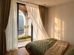 a bedroom with a bed next to a window at An House Son Tra in Danang