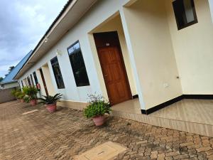 a house with potted plants and a wooden door at Kilimanjaro Magic MJ Branch in Old Moshi