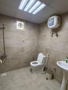 a bathroom with a toilet and a tv on the wall at thedesert08 in Ras al Khaimah +14 photos