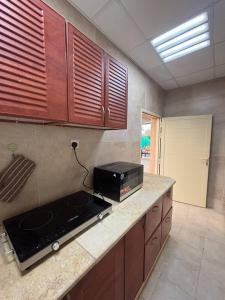 a kitchen with a stove and a microwave on a counter at thedesert08 in Ras al Khaimah