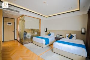 a hotel room with two beds and a bathroom at Ocean Delight Boutique Hotel 海悦精品酒店 in Sihanoukville +68 photos