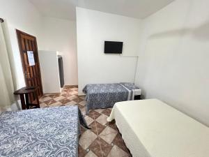 a room with two beds and a tv on the wall at Pousada Recanto Vila Viçosa in Nova Viçosa +37 photos