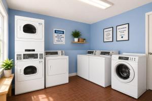 a laundry room with three washing machines and a washer and dryer at Kings Inn Anaheim at The Park & Convention Center in Anaheim