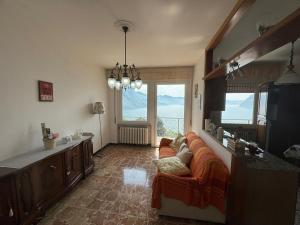 a living room with a couch and a large window at Casa Claudia in Riva di Solto