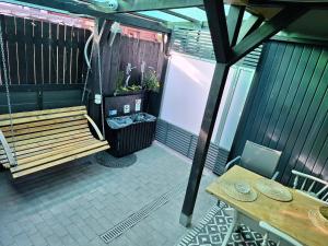 a patio with a bench and a table and chairs at Noclegi 2 pokoje in Szczecinek