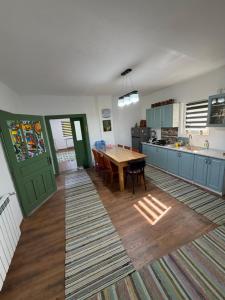 a kitchen with a wooden table and a dining room at La Paramon ! in Sângeorz-Băi