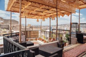 a balcony with chairs and a view of the city at Riad dar Kirami in Fez