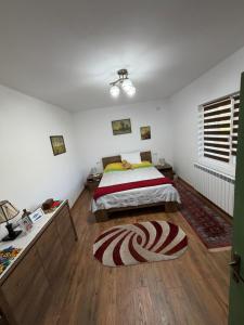 a bedroom with a bed and a wooden floor at La Paramon ! in Sângeorz-Băi