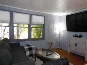 a living room with a couch and a tv at Indian Beach Cottage in Sarasota