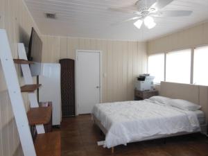 a bedroom with a bed and a ceiling fan at Indian Beach Cottage in Sarasota