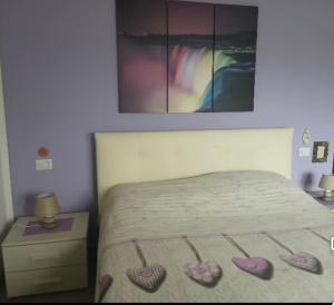 a bedroom with a bed with three hearts on it at Angela's House in Barga