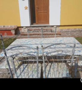 a metal bed with a table in front of a building at Angela's House in Barga