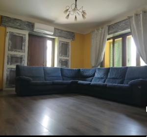 a blue couch in a living room with windows at Angela's House in Barga +1 photo