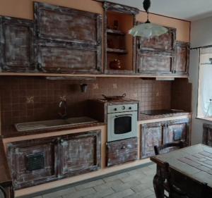 an old kitchen with wooden cabinets and a stove at Angela's House in Barga