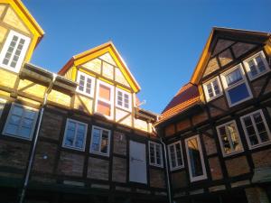 eine Reihe von Holzgebäuden mit weißen Fenstern in der Unterkunft Fachwerkresidenz Deuterscher Hof in Quedlinburg