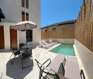 a patio with chairs and an umbrella and a pool at Hotel Boutique Alcalá Vallarta in Puerto Vallarta