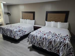 two beds in a hotel room with two bedsskirts at Red Roof Inn Green Brook - Somerset in Green Brook