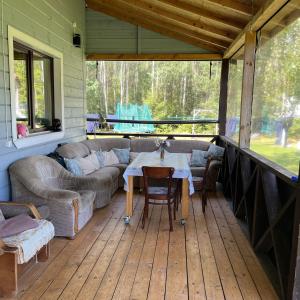 a screened in porch with a couch and a table at Malinada-kaimo sodyba in Šalčininkai