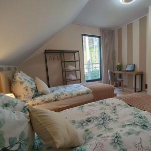 a bedroom with two beds and a desk and a window at W Sosnowym Lesie Pluski in Pluski