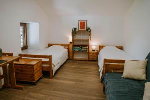 a room with two beds and a couch in it at Hiša Potoki in Kobarid
