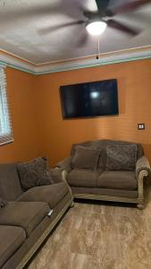 a living room with a couch and a flat screen tv at Villa Simon Guest house in Les Cayes