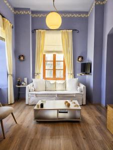 a living room with a white couch and a table at Arion Syros Luxury Rooms and Suites in Ermoupoli