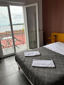 a bedroom with a bed with two towels on it at Le Moutchico in Lacanau +4 photos