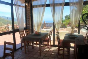 ein Esszimmer mit 2 Tischen und Meerblick in der Unterkunft Villa Almoezia Charming B&B in Taormina
