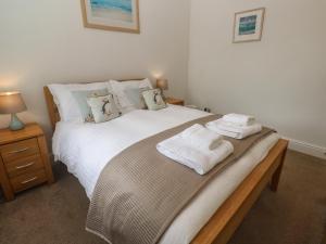 a bedroom with a bed with towels on it at Apartment 1 Llewellan in Carbis Bay
