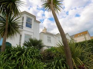 a white house with palm trees in front of it at Apartment 1 Llewellan in Carbis Bay