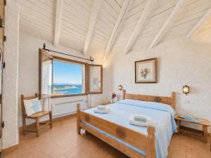 a bedroom with a large bed and a window at Sea View Three-Bedroom House 50m from the Beach in Baja Sardinia