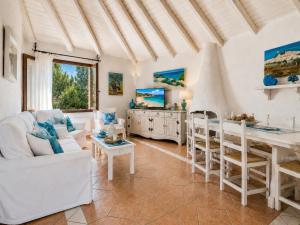 a living room with a white couch and a table at Sea View Three-Bedroom House 50m from the Beach in Baja Sardinia