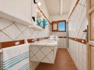 a white bathroom with a sink and a mirror at Sea View Three-Bedroom House 50m from the Beach in Baja Sardinia