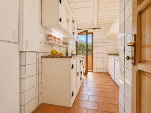 a kitchen with white cabinets and a tile floor at Sea View Three-Bedroom House 50m from the Beach in Baja Sardinia +13 photos